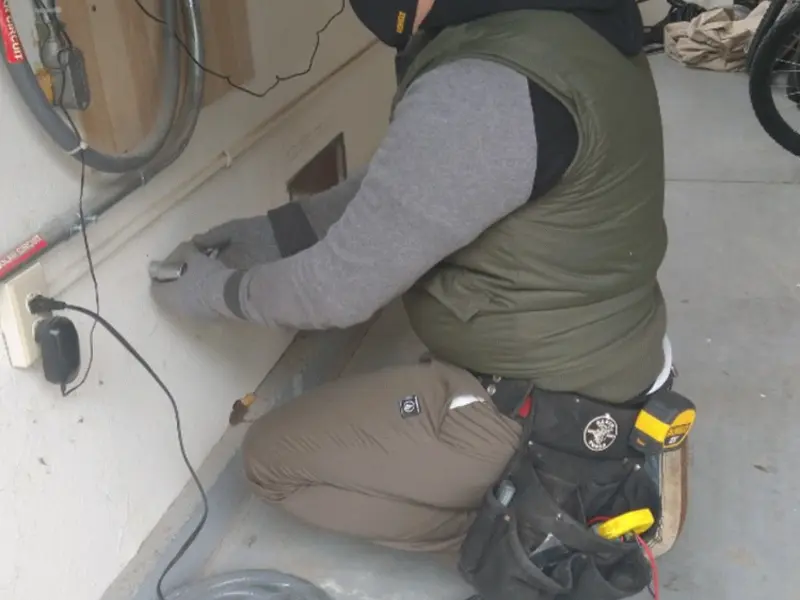 Electrician performing outlet wiring in a Millington garage